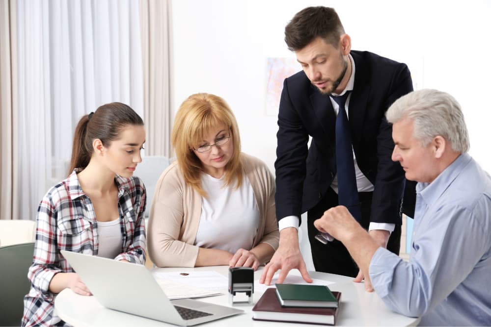 public adjuster discussing insurance policy and claim with family sitting around table